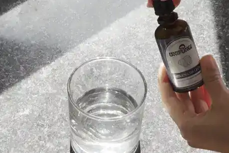Las gotas cayendo en el vaso de agua